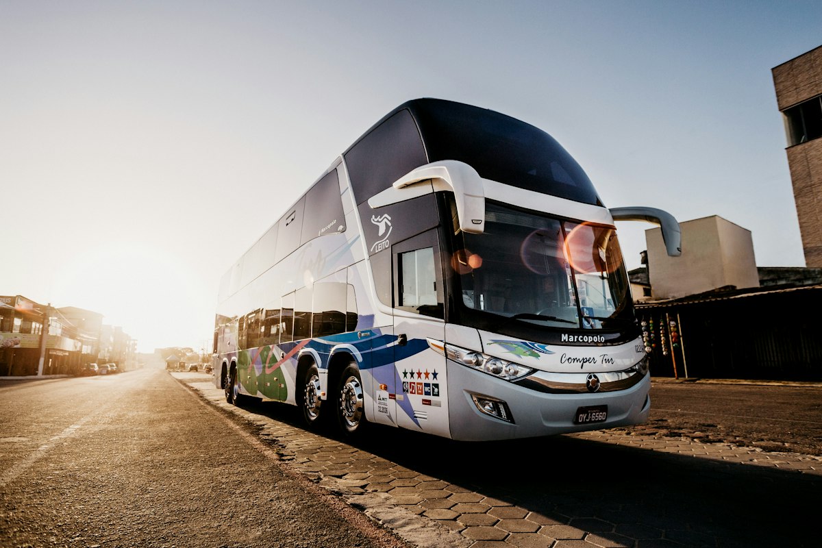 Autocar de transporte de viajeros estacionado en una calle al atardecer.